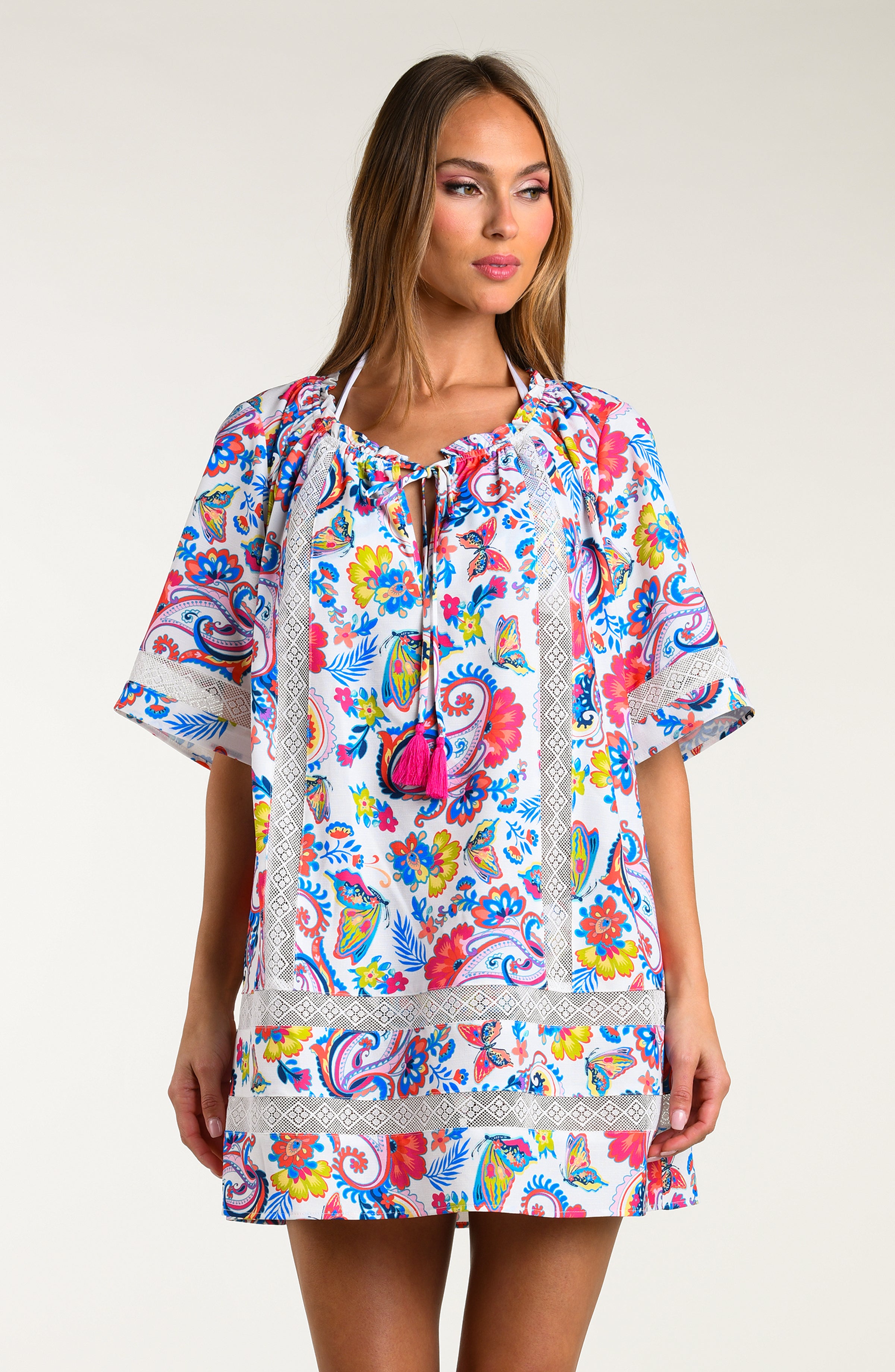 Woman wearing a multicolored tunic cover up against a white background.