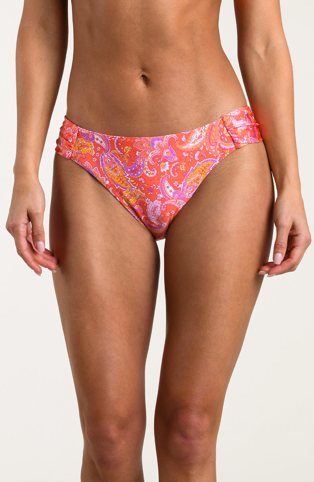 Person wearing a pink and orange multicolored bikini bottom on a white background