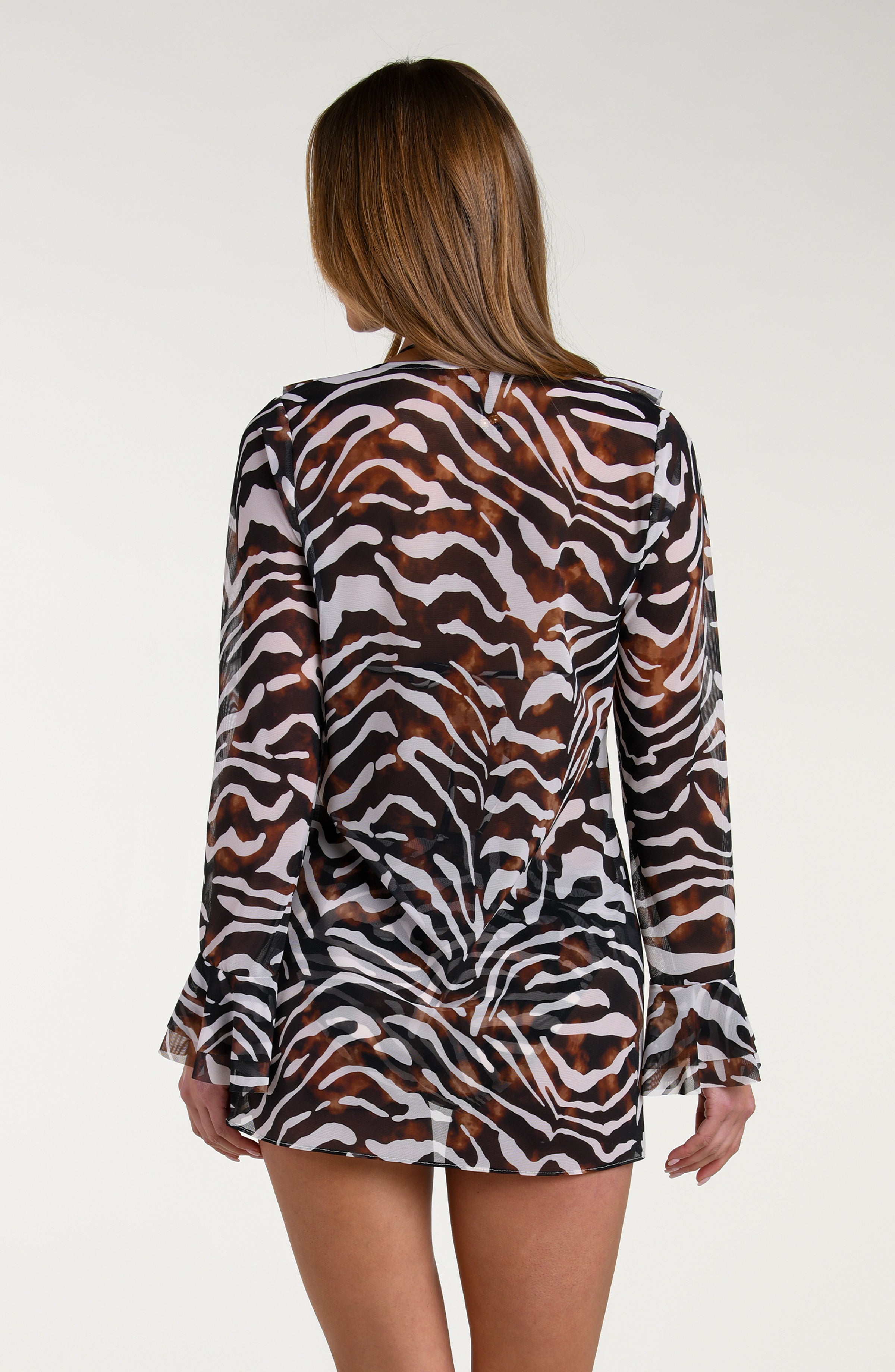 Woman wearing a zebra print sheer cardigan over a bikini against a white background.