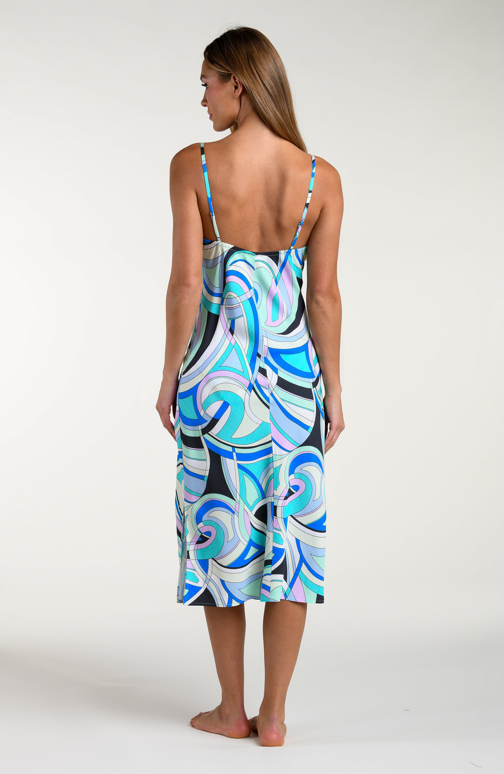 Woman wearing a multicolored patterned midi dress against a white background