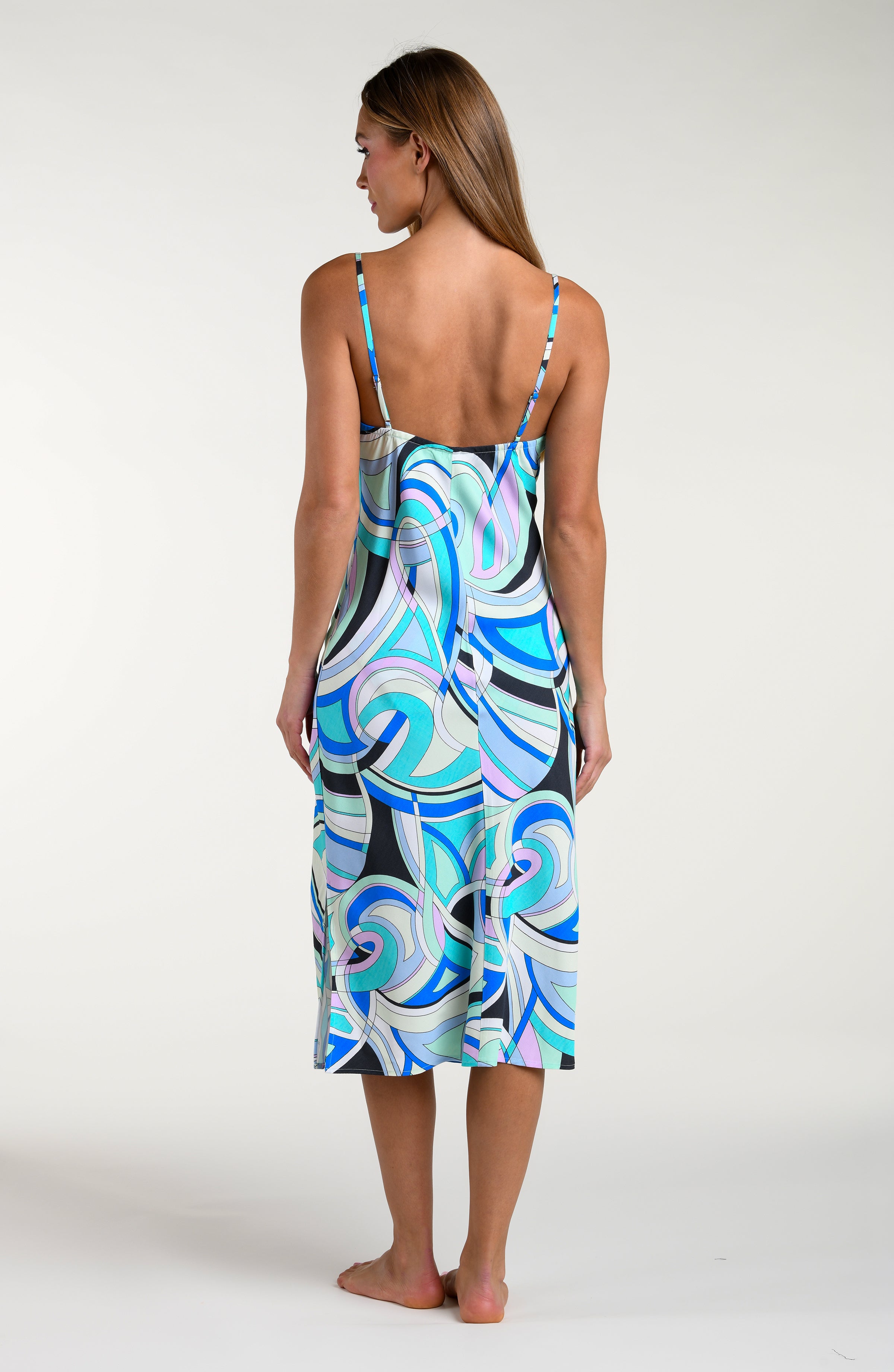 Woman wearing a multicolored patterned midi dress against a white background
