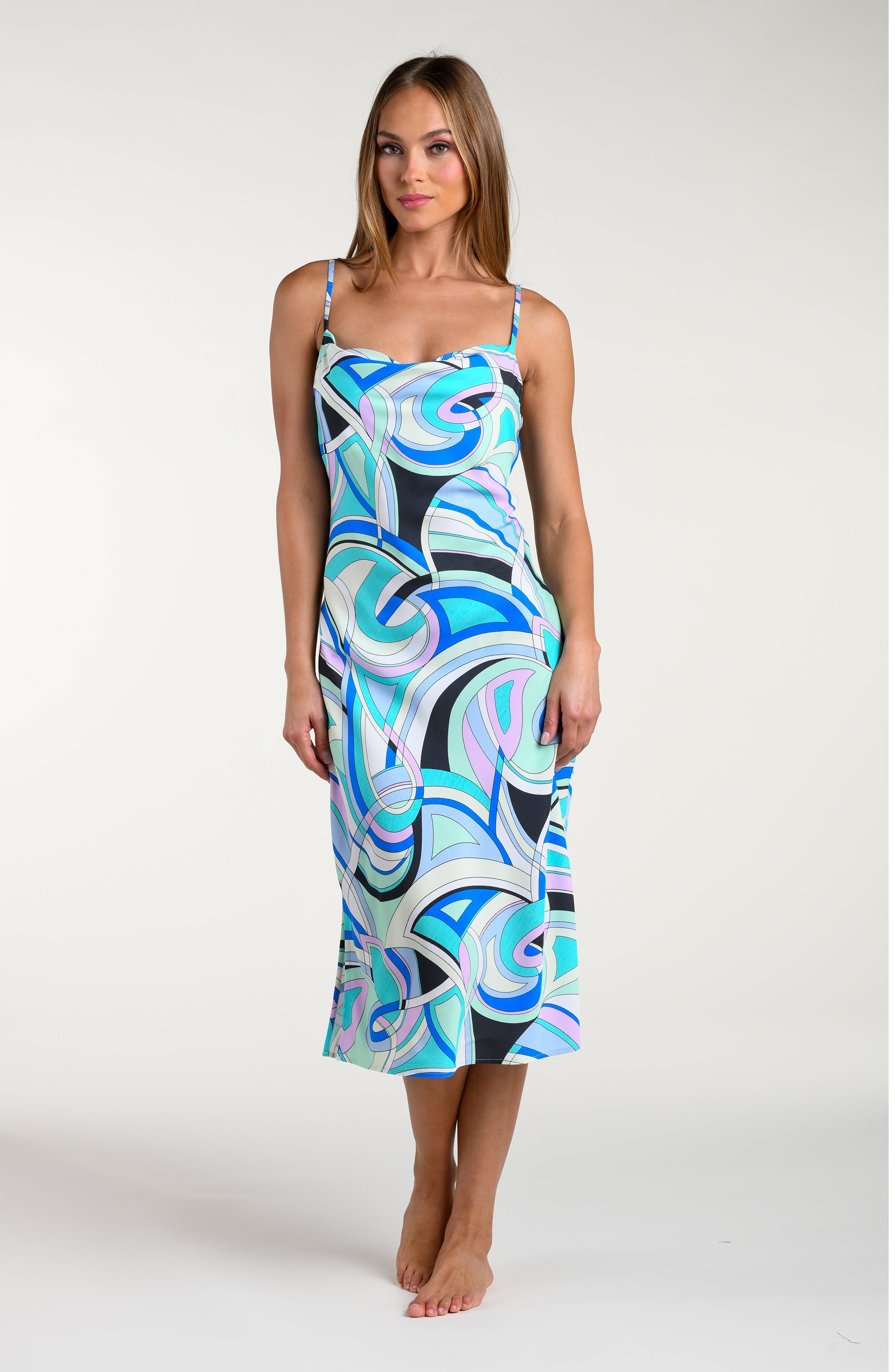 Woman wearing a multicolored patterned midi dress against a white background