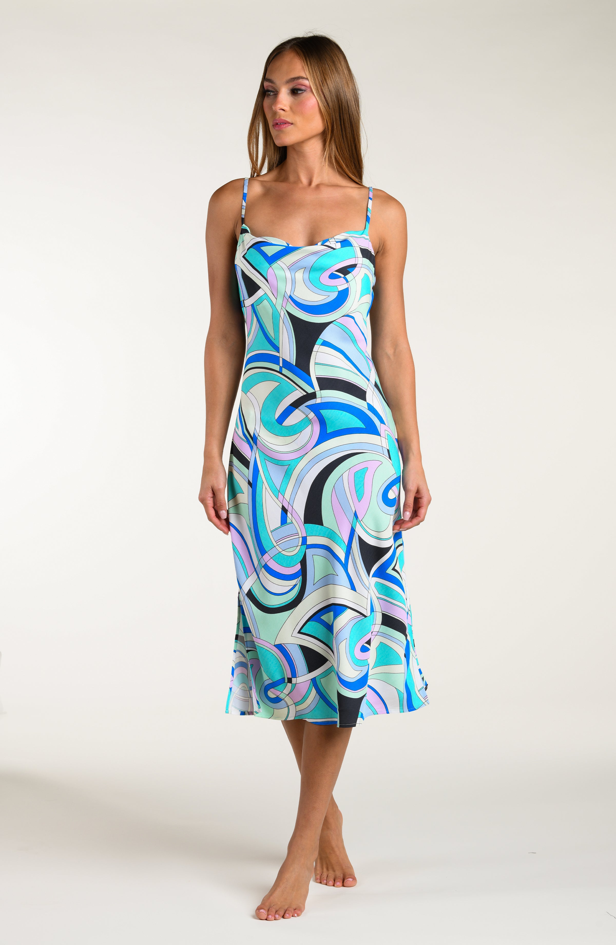 Woman wearing a multicolored patterned midi dress against a white background