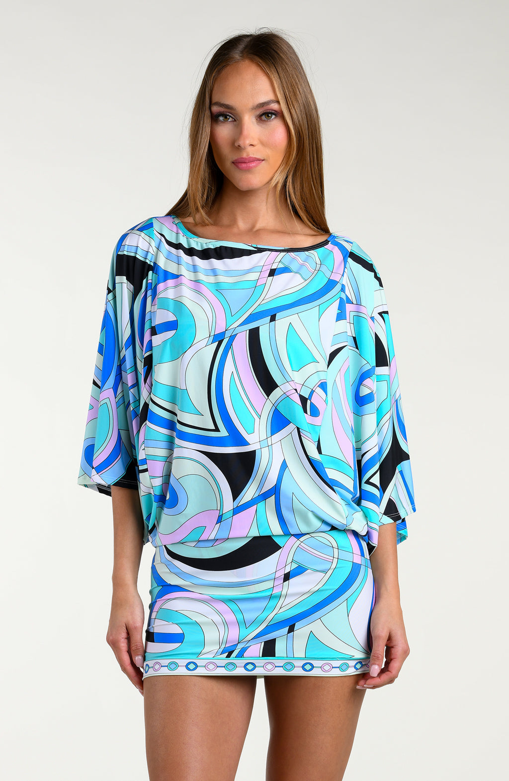 Woman wearing a multicolored one-piece swimsuit against a white background