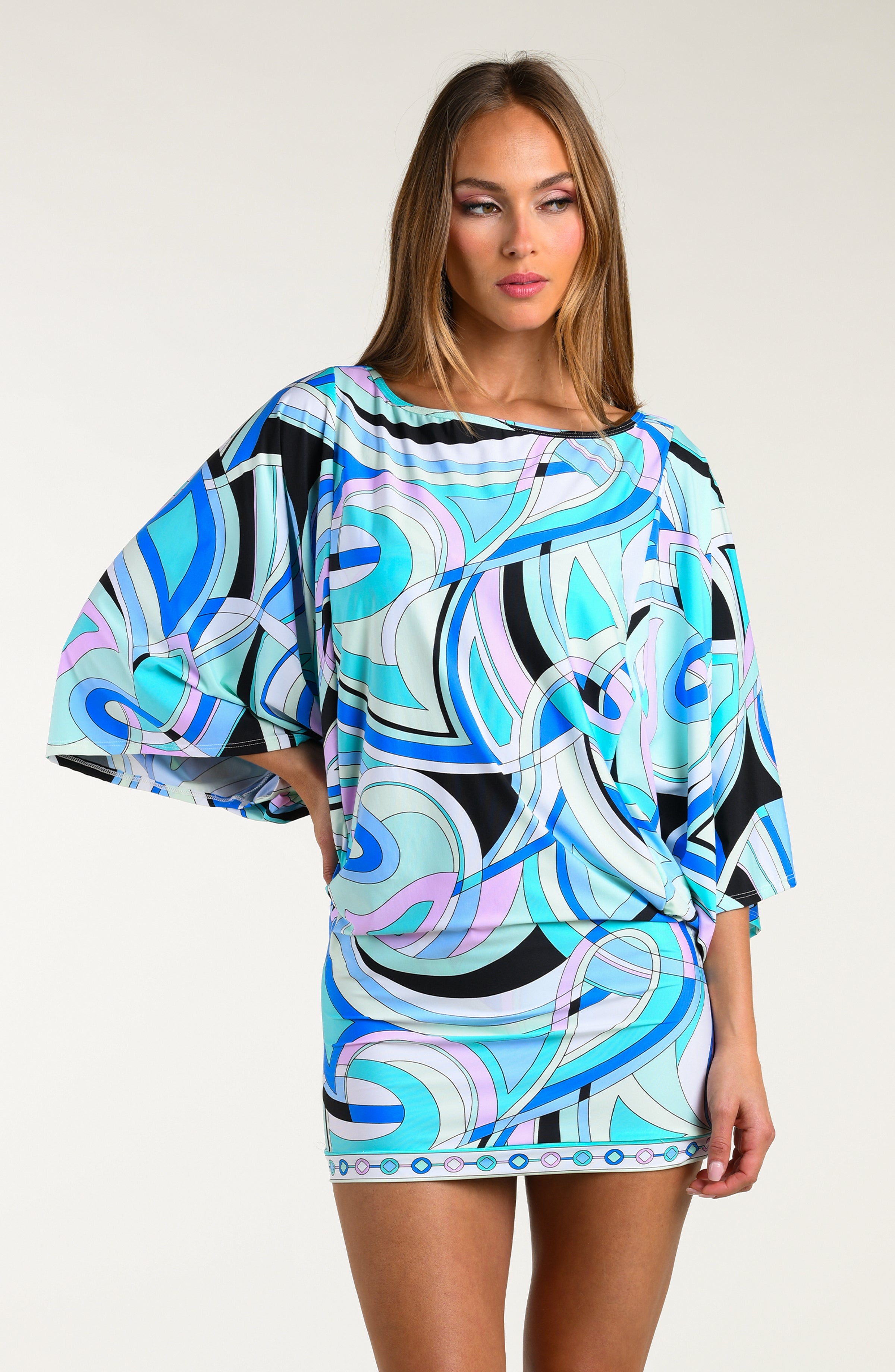 Woman wearing a multicolored one-piece swimsuit against a white background