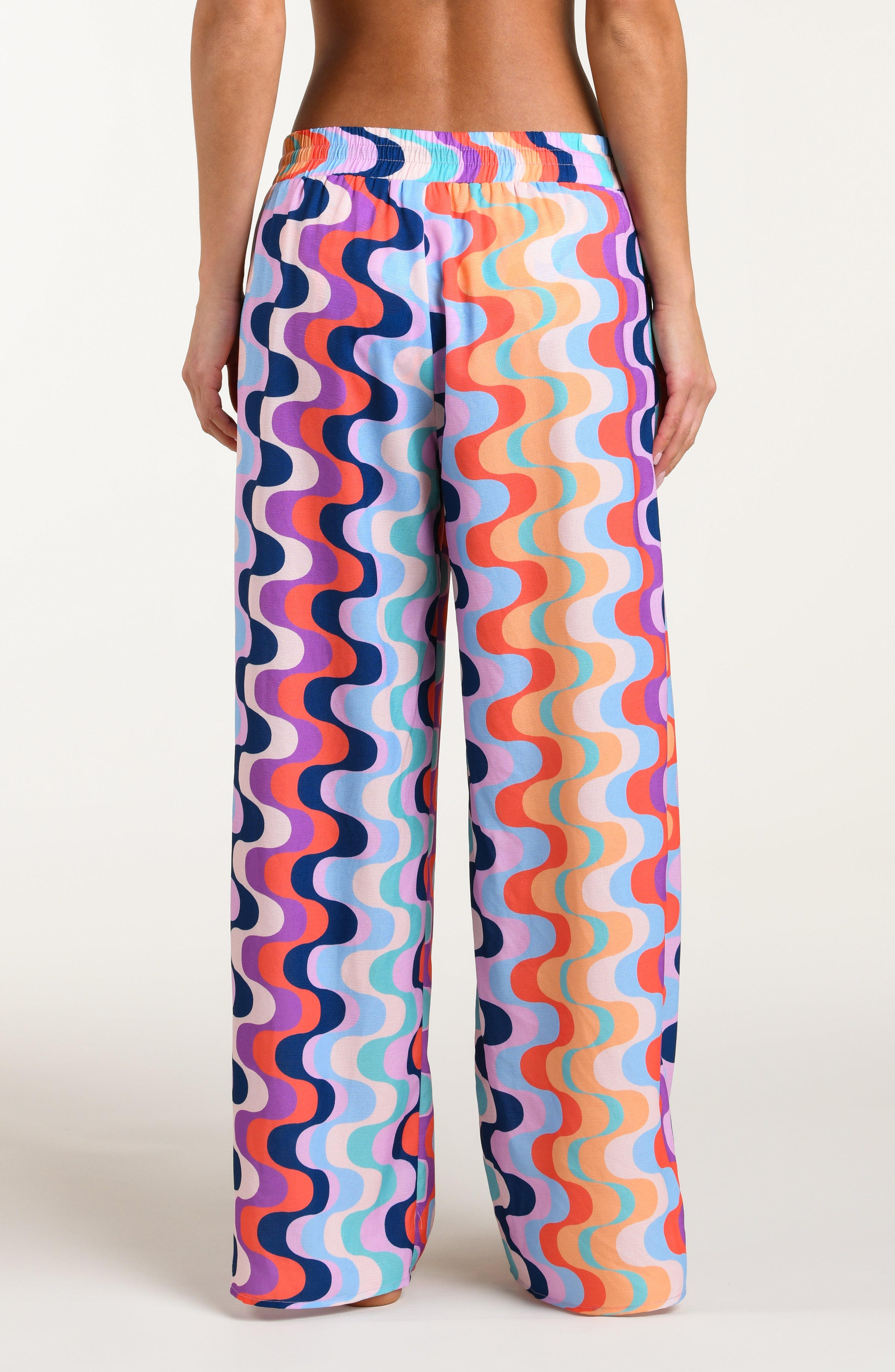 Colorful patterned pants worn by a person on a white background