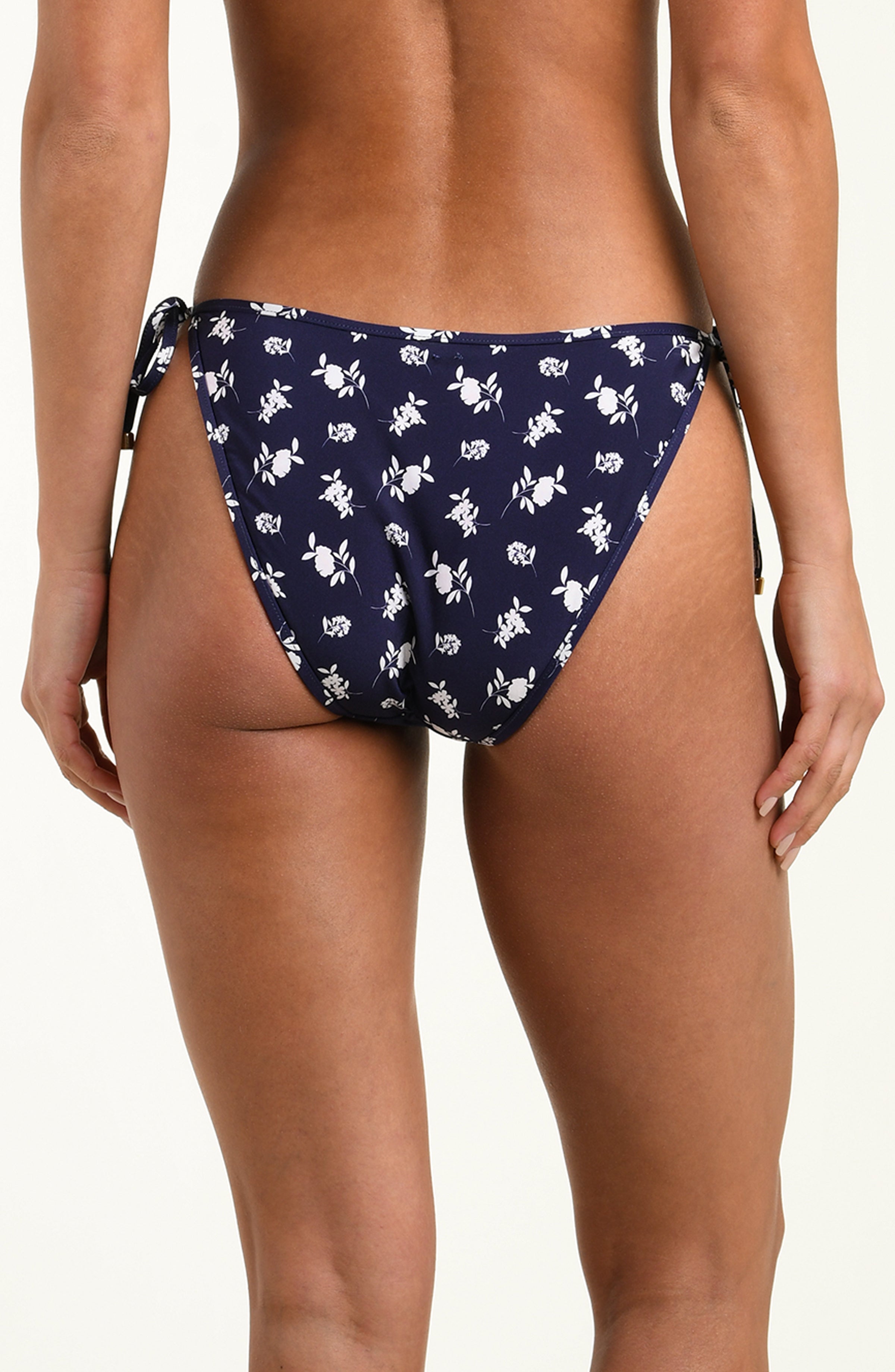Navy blue bikini bottom with white pattern on a model against a white background