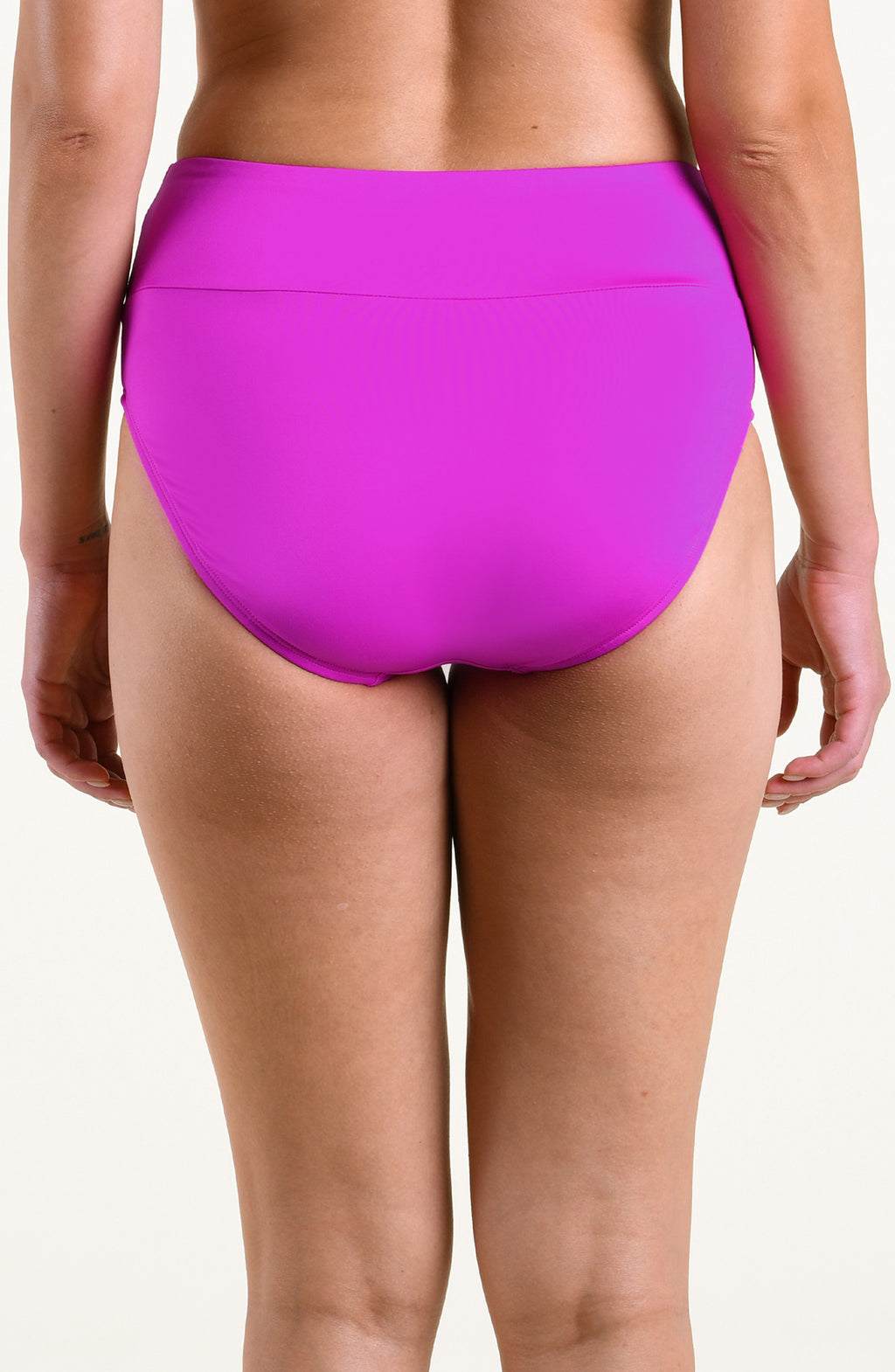 A model wearing bright orchid high-waisted bikini bottoms against a plain light background.