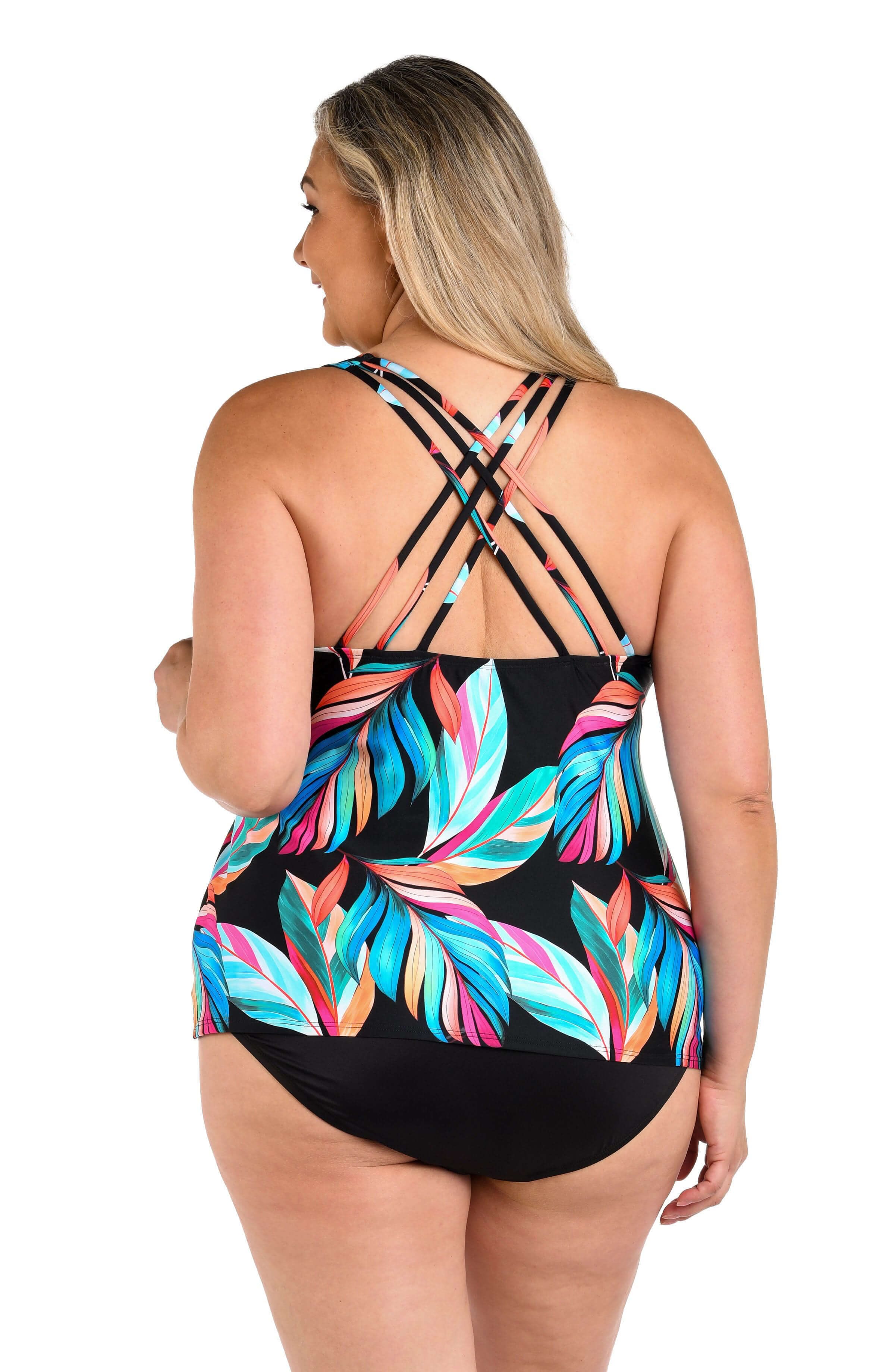 Woman wearing a colorful leaf-patterned tankini top on a white background
