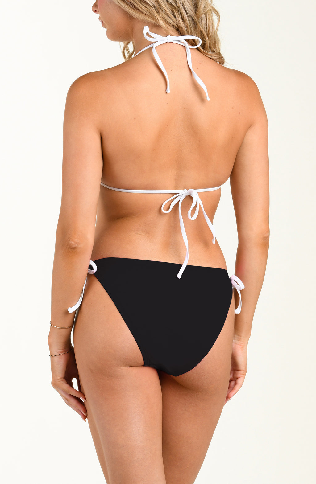 Black bikini bottom with white strings worn by a person on a white background