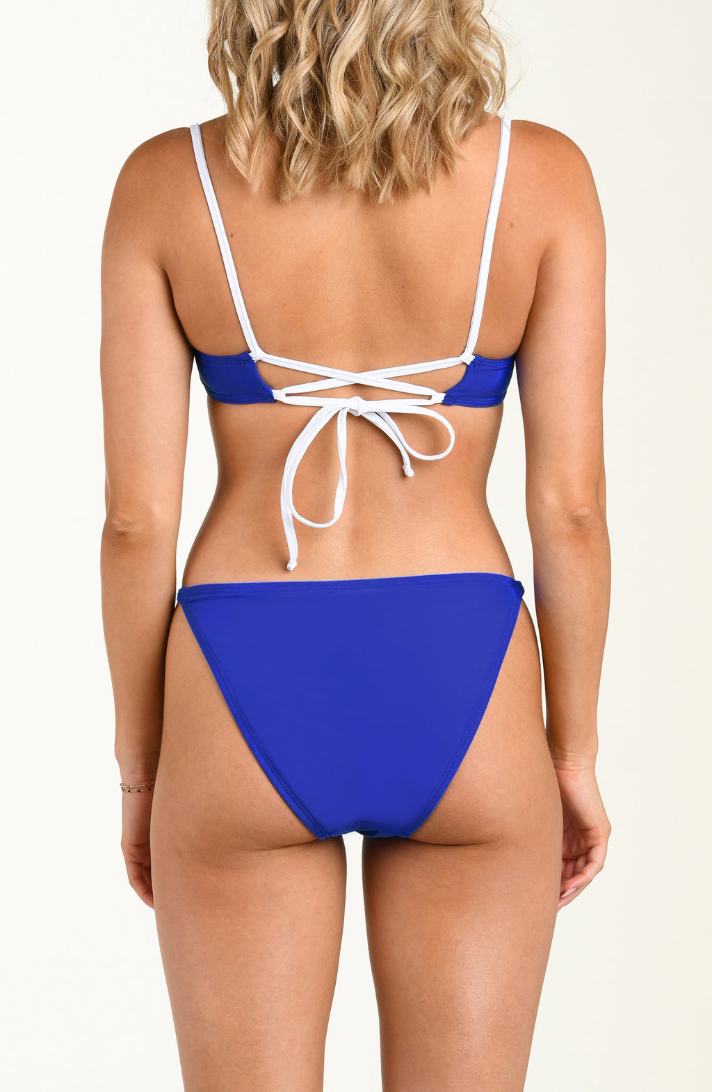 Blue bikini with white straps on a plain background