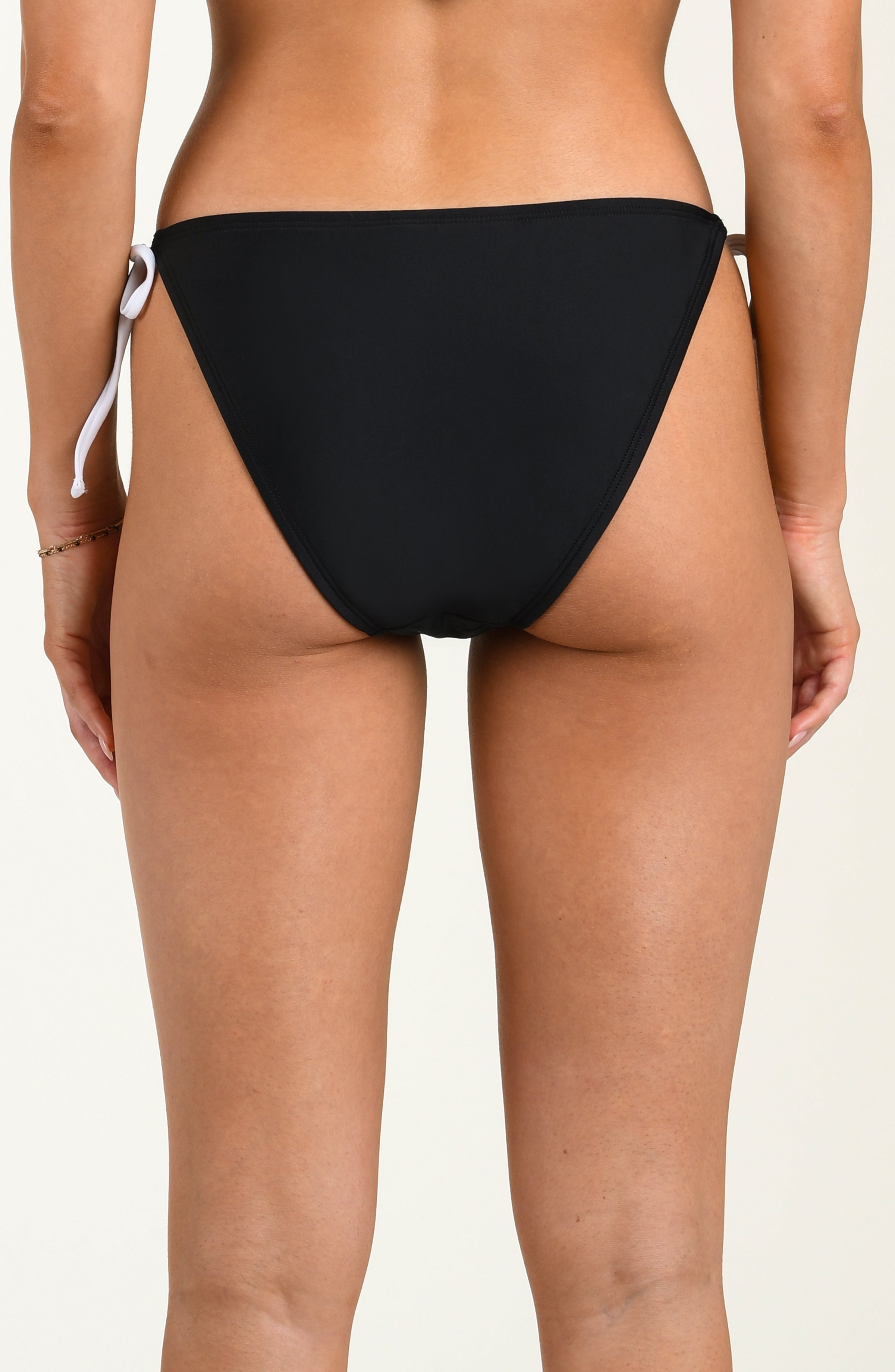 Black bikini bottom on a beige background