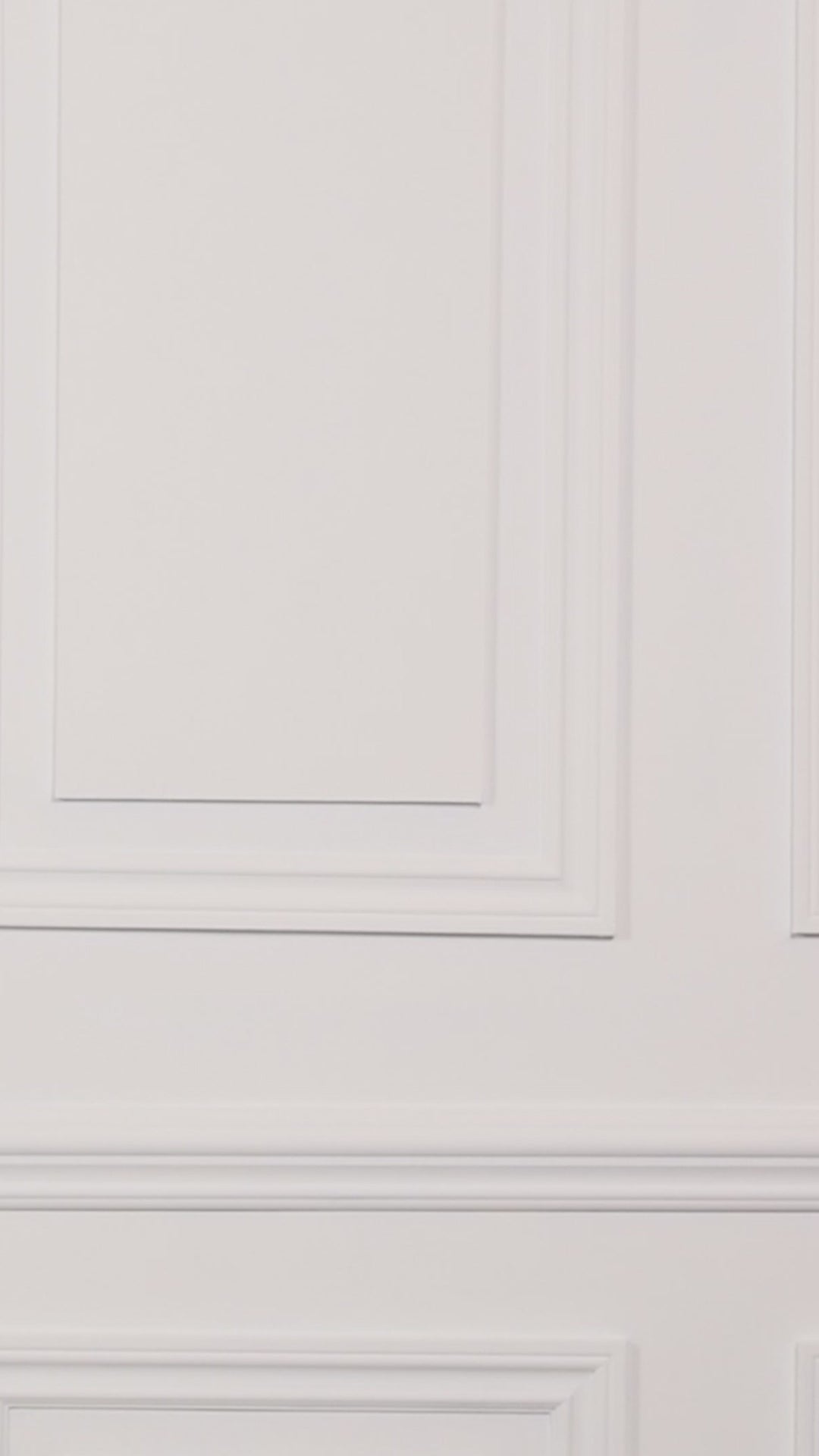 Video of a woman wearing a colorful floral tankini top and black black bottoms on a plain background