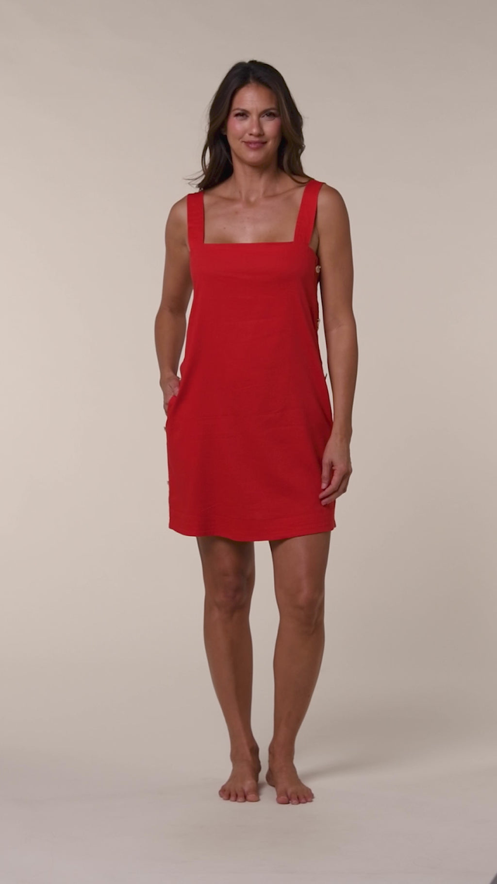 Video of a woman wearing a red sleeveless cover up dress on a white background